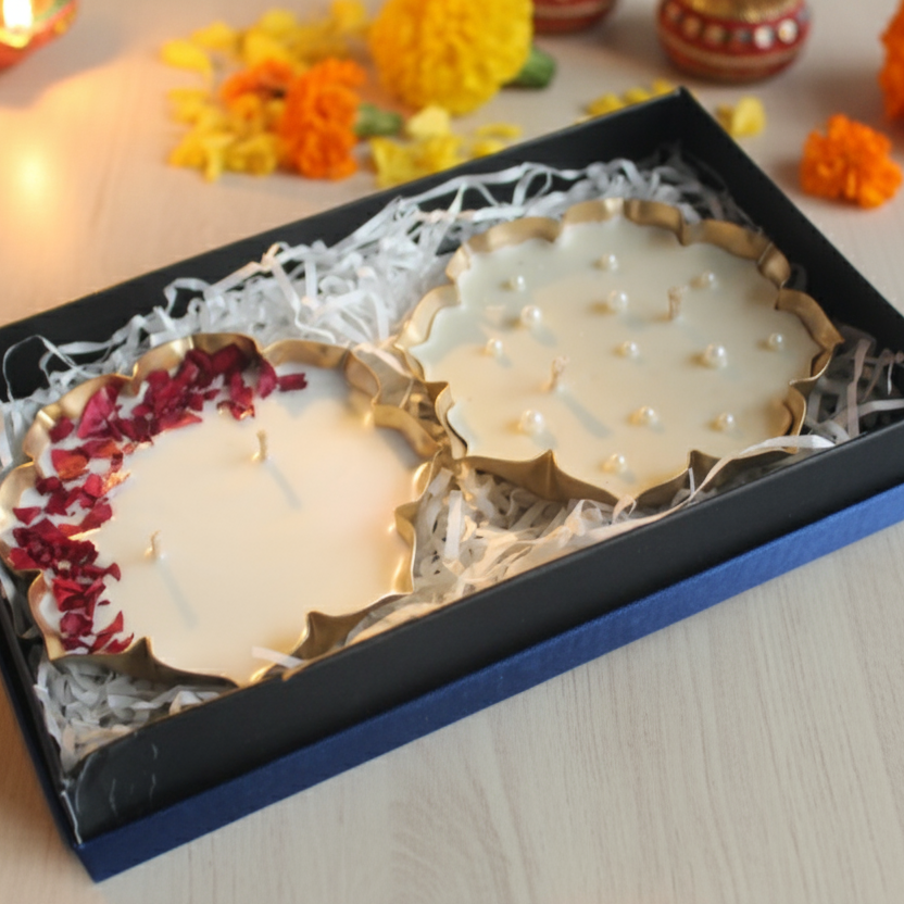 Decorative urli candles in a box with flowers and lights on a wooden surface